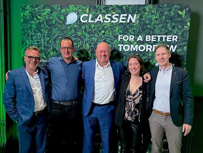 Zdjęcie grupowe pięciu osób przed CLASSEN z hasłem „Floors for a better tomorrow” – symbolem ducha zespołowego, zrównoważonego rozwoju i przyszłości ekologicznych wykładzin podłogowych.