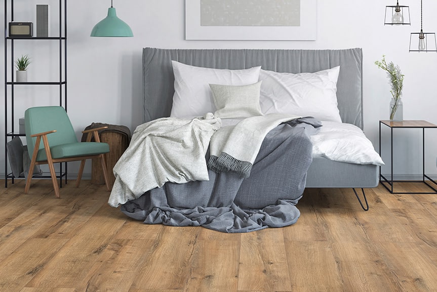 Sypialnia z szarą pościelą i drewnianą podłogą