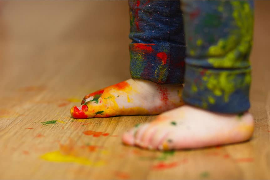 Dziecięce stopy na lakierowanej podłodze - kreatywność i wytrzymała podłoga