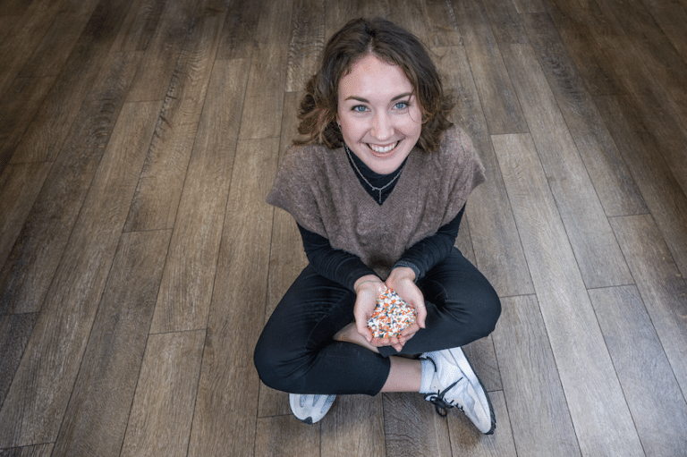 Woman sitting on wooden floor - cozy living room with warm flooring