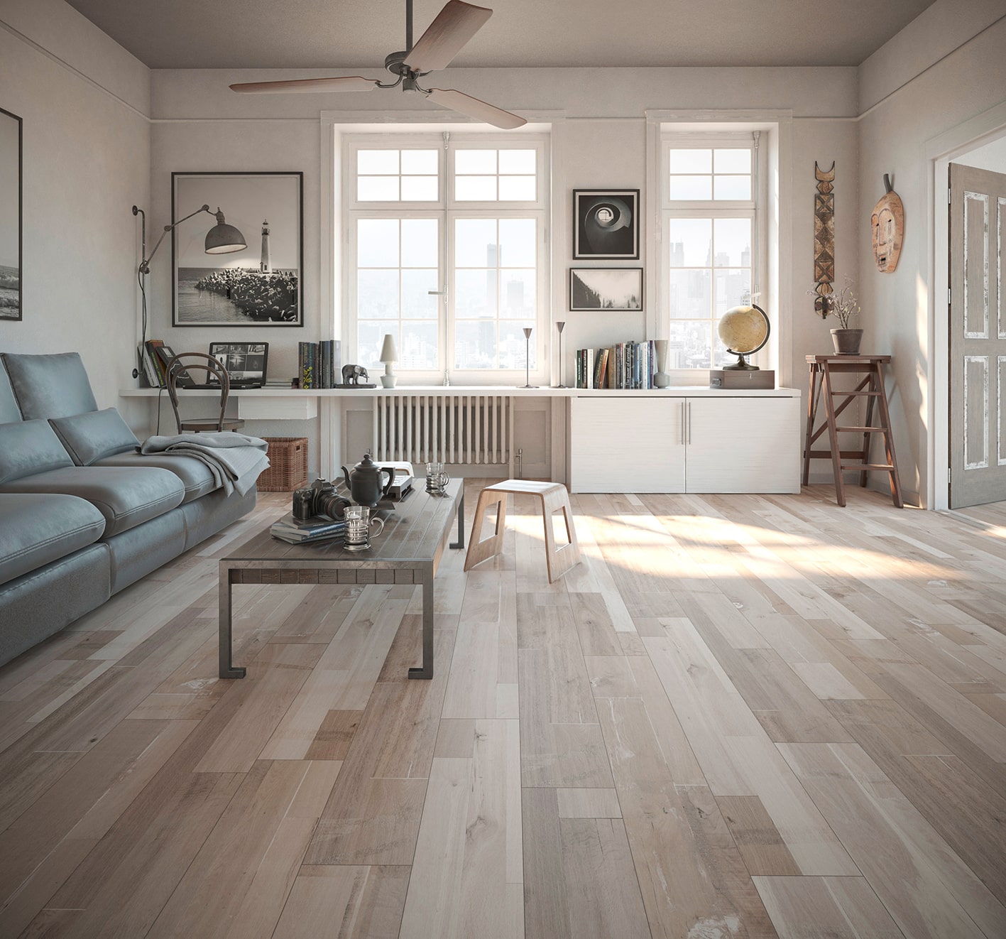 A large living room with wood-look flooring, a gray couch, and a wooden table