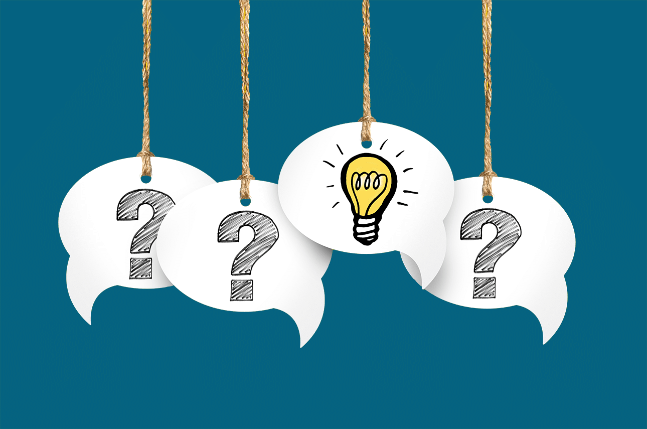 Four paper speech bubbles are hanging from four strings. Three of them have question marks on them, and one has a glowing light bulb.